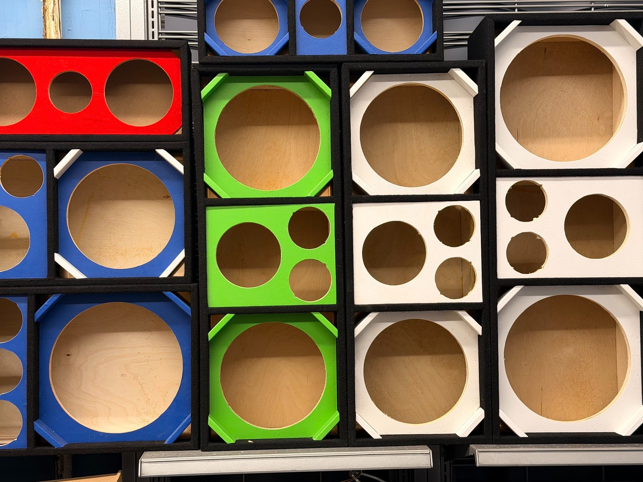 Wall of custom-built speaker boxes in various colors